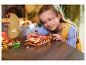 Une fille sourit en jouant avec des ensembles LEGO Friends, dont un bateau.