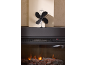 Ventilateur de poêle noir alimenté par la chaleur sur une cheminée électrique avec bûches incandescentes.