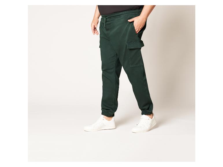 Pantalon cargo vert avec des baskets blanches.