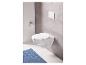 Des toilettes murales blanches avec un tapis de bain bleu et un porte-papier toilette.