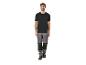 Homme en t-shirt noir et pantalon de travail gris.