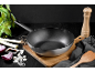 Wok avec ingrédients frais et ustensiles de cuisine sur bois foncé.