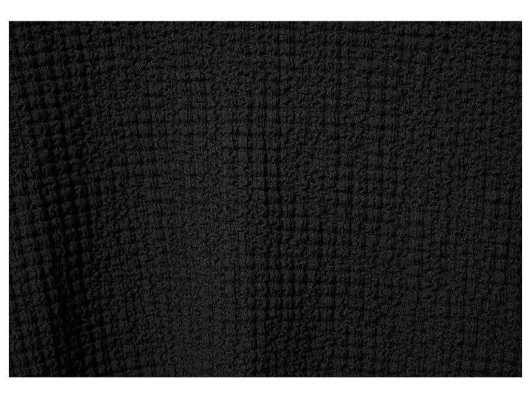 Tissu noir texturé avec une surface froissée.