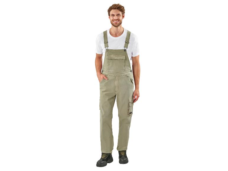 Un homme portant une salopette verte et des chaussures de travail.