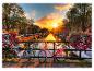 Deux vélos sur un pont avec des jardinières, dans un canal d'Amsterdam au coucher du soleil.