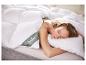 Femme dormant paisiblement dans un lit avec une couette et un oreiller blancs, étiquette visible.