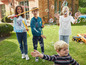 Des enfants jouent avec des bulles et un camion jouet dans le jardin.
