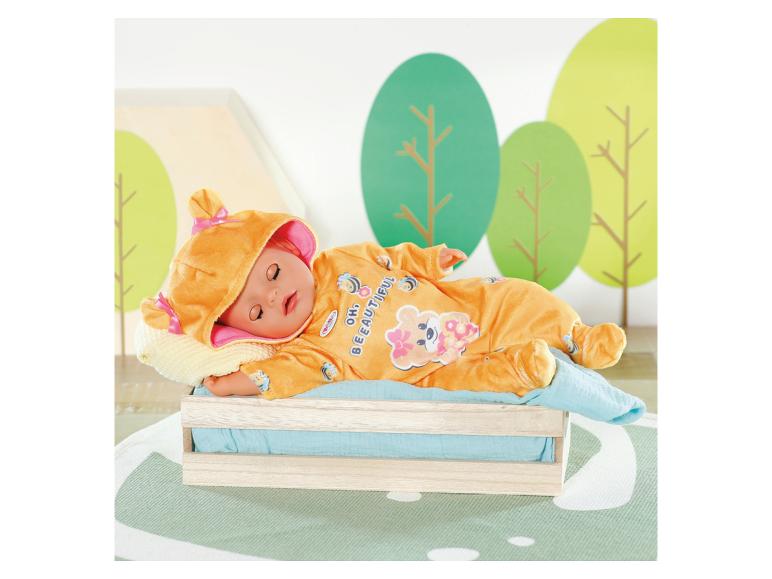 Poupée BABY born en grenouillère orange thème abeille, dormant dans un lit en caisse en bois.