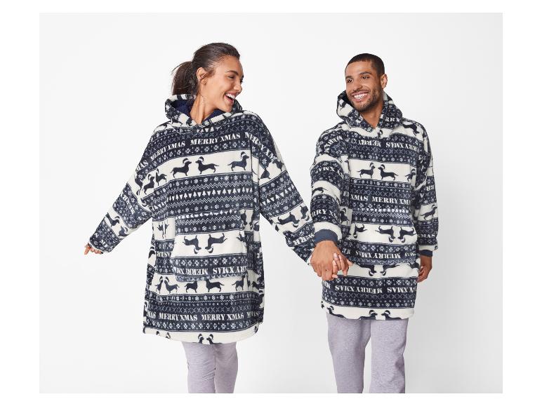 Deux personnes souriantes portent des sweats à capuche moelleux assortis avec un motif de teckels de Noël.