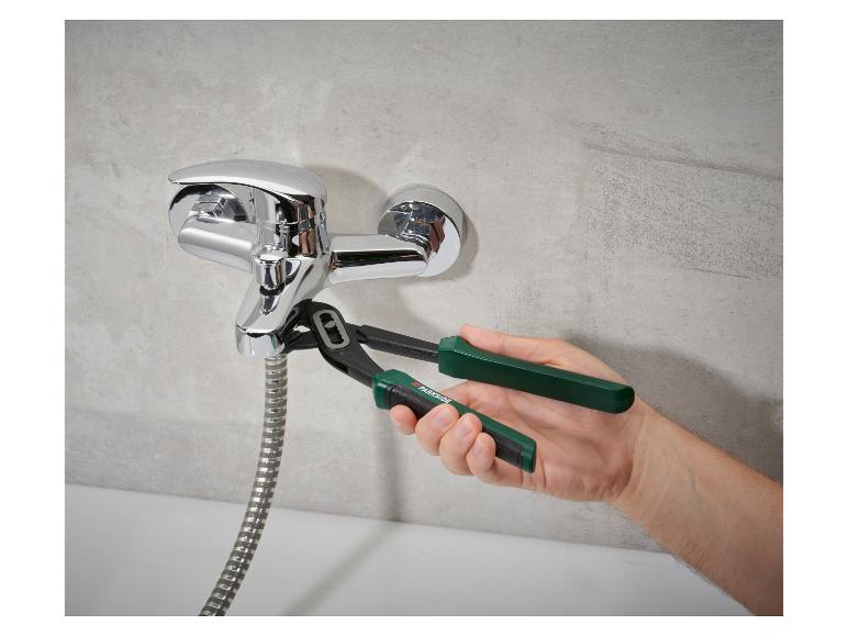 Pince Parkside ajustant un mitigeur de douche chromé avec flexible.