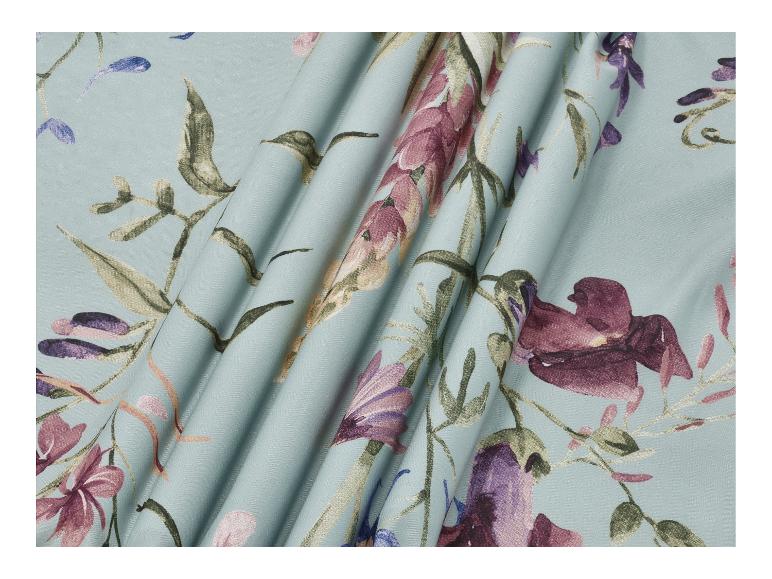 Tissu turquoise clair avec motifs floraux violets et verts, drapé.