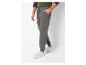 Homme portant un pantalon de survêtement cargo gris et des baskets blanches.