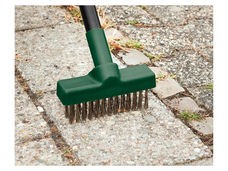 Brosse à désherber à poils métalliques nettoyant les mauvaises herbes entre les pavés