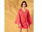 Une femme porte une robe rose à imprimé orange.