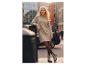 Femme en robe pull beige et collants marron, posant en ville.