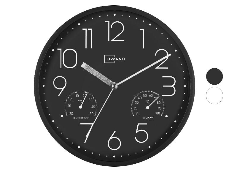 Horloge murale noire avec thermomètre et hygromètre intégrés, grands chiffres blancs.
