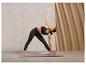 Une femme faisant du yoga avec un bloc de yoga et un tapis sur un sol en béton.