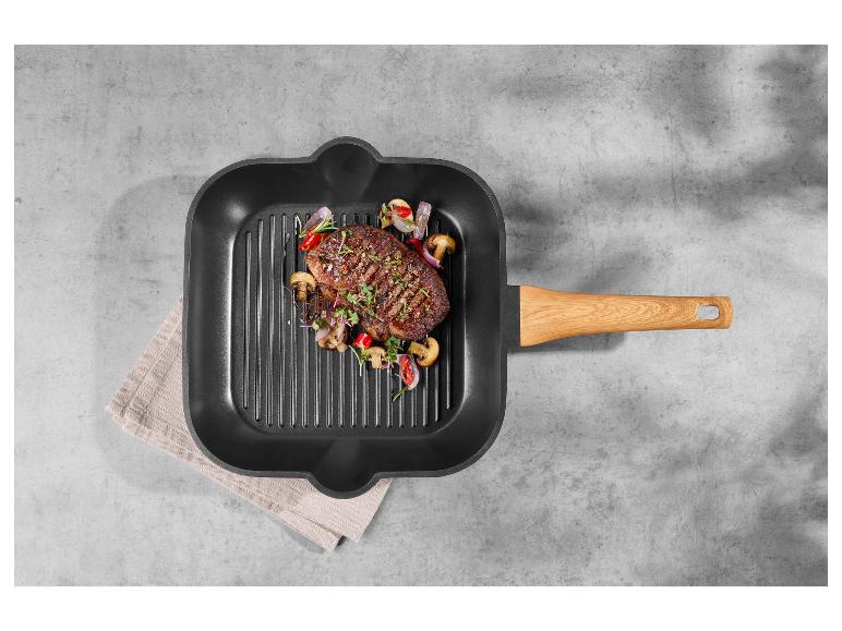 Steak aux légumes dans une poêle grill avec une poignée en bois.