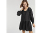 Une femme porte une robe noire à manches longues.