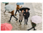 Un couple se tient sous un parapluie dans une rue pluvieuse.