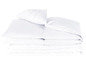 Une pile de couettes et d'oreillers blancs