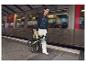 Une femme avec un vélo pliable Tern à la gare.