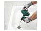 Homme ganté utilisant un déboucheur manuel dans une baignoire.