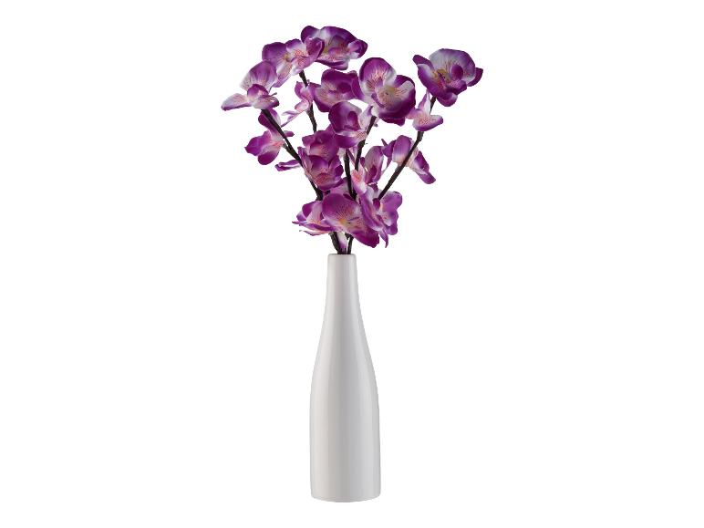 Orchidées violettes artificielles dans un vase blanc