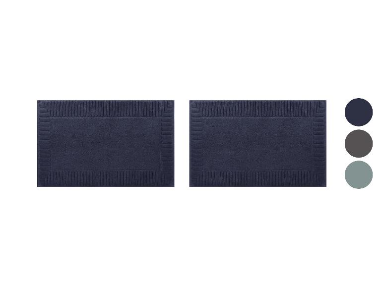 Deux tapis de bain rectangulaires bleu marine avec un motif texturé en relief.