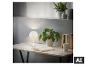 Lampe de table blanche sur un bureau en bois avec plantes et livres.