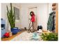 Femme nettoyant un tapis avec un aspirateur eau et poussière, enlevant les taches de boue.