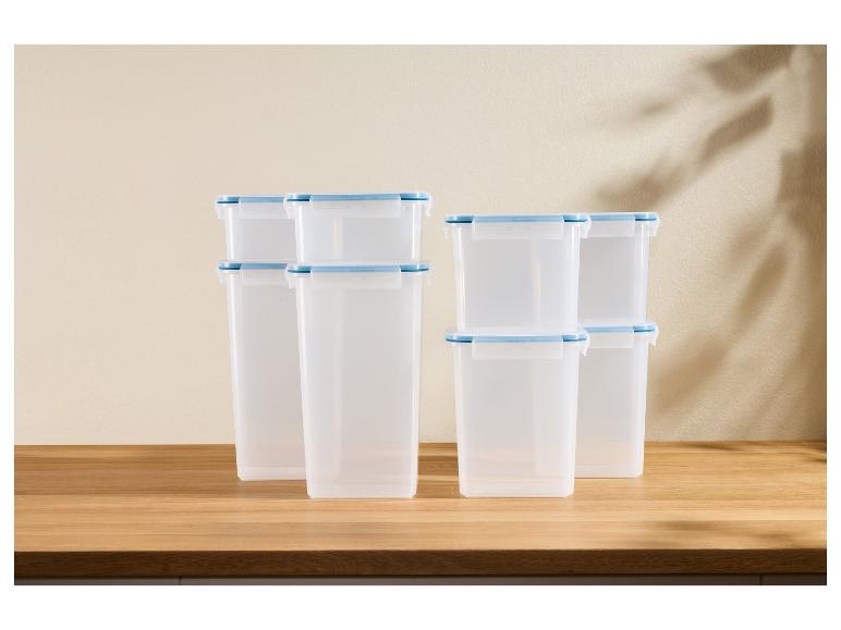 Conteneurs de rangement en plastique transparent avec couvercles bleu ciel sur un comptoir en bois.