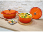 Deux casseroles en fonte orange avec couvercle, l'une avec du curry et des légumes.