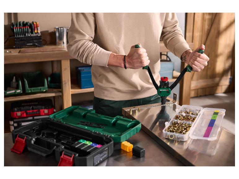 Personne utilisant un pistolet à rivets Parkside avec un jeu de rivets et d'outils sur un établi.