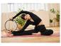 Une femme faisant des exercices de pilates avec un anneau sur un tapis de yoga.