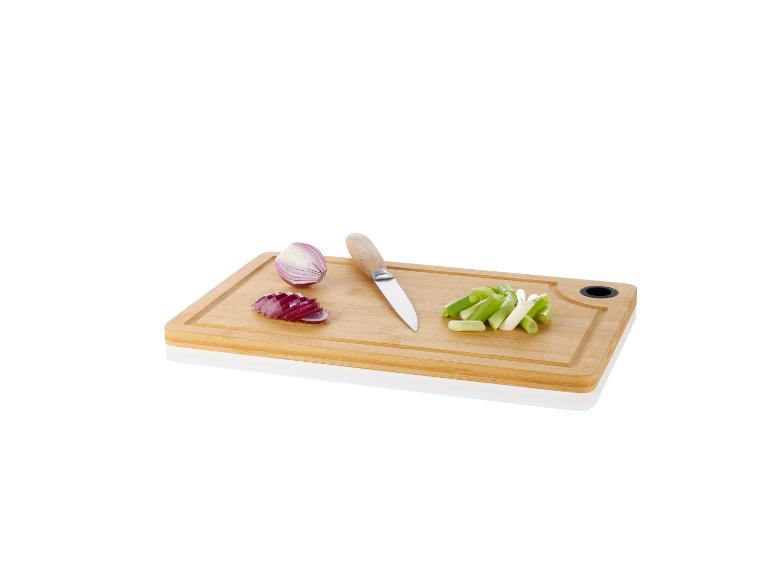 Planche à découper en bambou avec oignons rouges, oignons verts et couteau.