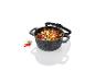 Une casserole noire avec un couvercle en verre, remplie de légumes rôtis et de feta.