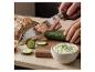 Couteau de cuisine premium SILVERCREST® coupant un concombre sur une planche avec du tzatziki et du pain.