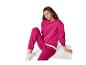 Une femme en sweat-shirt fuchsia et pantalon de survêtement assorti assise sur une surface blanche.