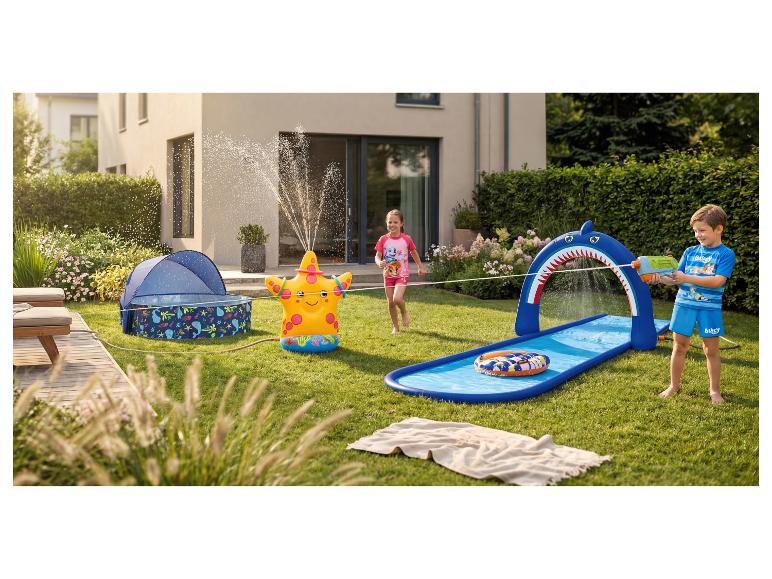 Enfants jouant dans le jardin avec un arroseur gonflable en forme d'étoile de mer et un toboggan aquatique requin.