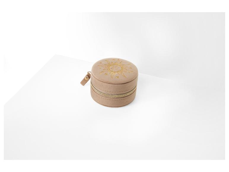 Une boîte à bijoux en velours beige avec un motif soleil.