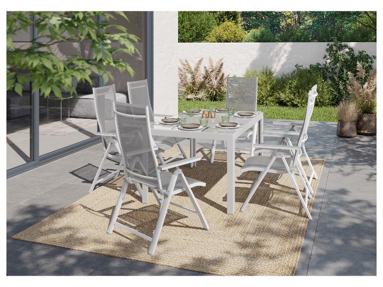 Ensemble de table et chaises pliantes blanches pour extérieur, sur un tapis beige.