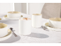 Élégant service de table en céramique blanche avec tasses et bols sur une nappe blanche
