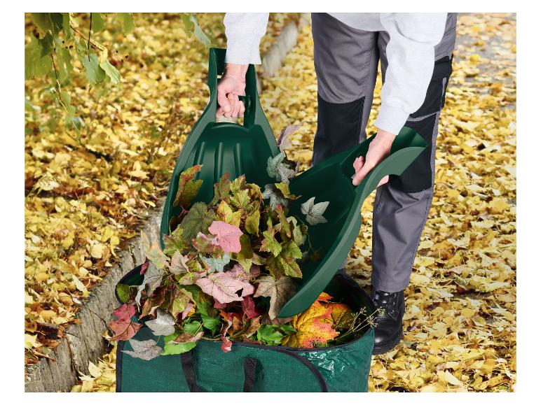Personne ramassant des feuilles d'automne dans un sac de jardin vert avec des ramasse-feuilles.