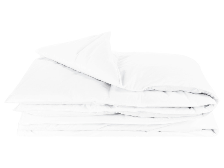 Une couette et un oreiller blancs, pliés.