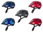 Quatre casques de vélo pour enfants différents avec des motifs variés.