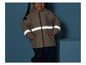 Un enfant porte un imperméable avec des bandes réfléchissantes et un pantalon.