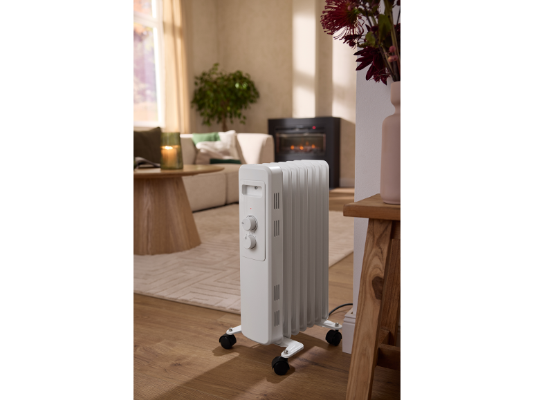 Radiateur à bain d'huile blanc portatif dans un salon chaleureux.