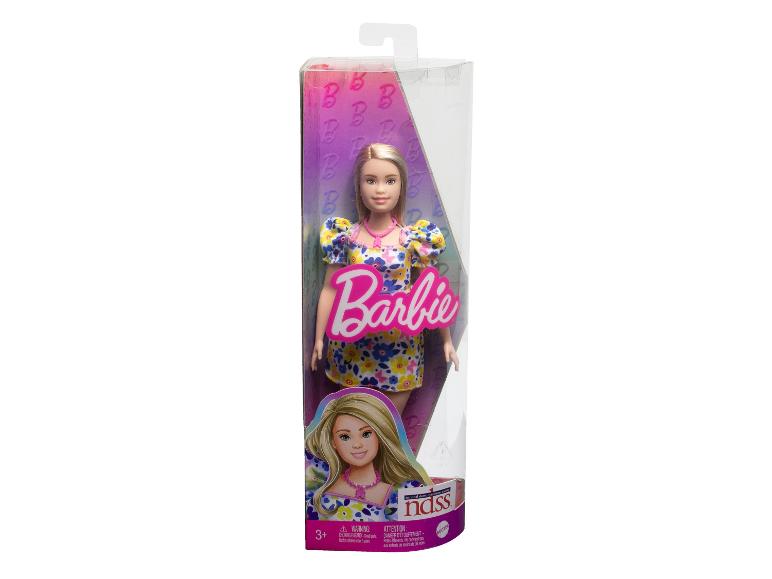 Poupée Barbie dans son emballage, portant une robe à fleurs.