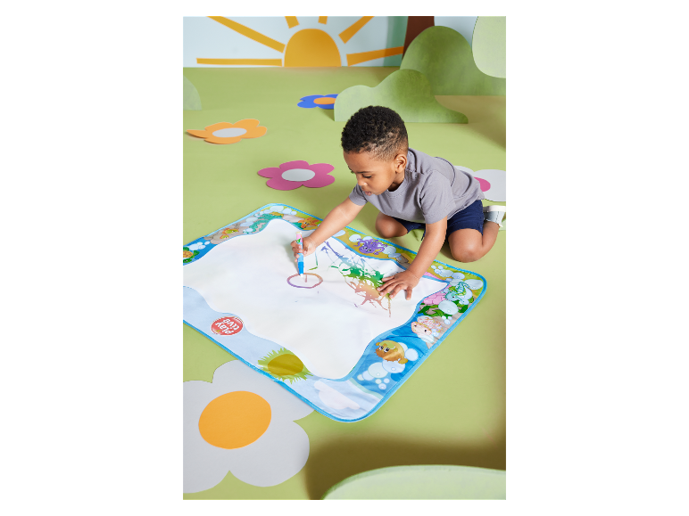Un enfant dessine sur un tapis magique Play-Doh.
